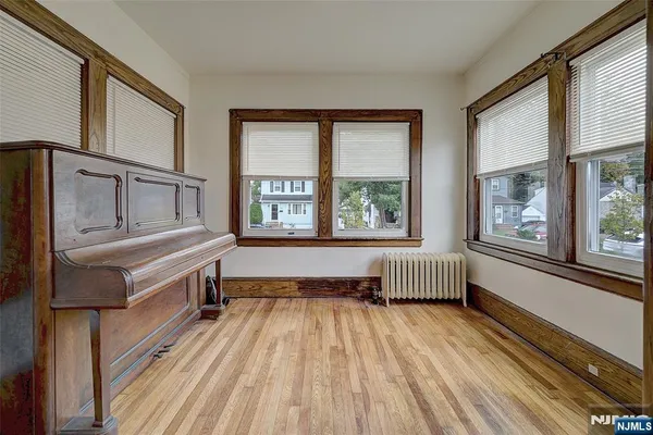 a spacious bedroom with a bed and wooden floor