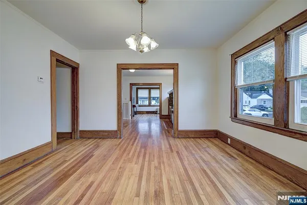 a view of a room with wooden floor chandelier and windows