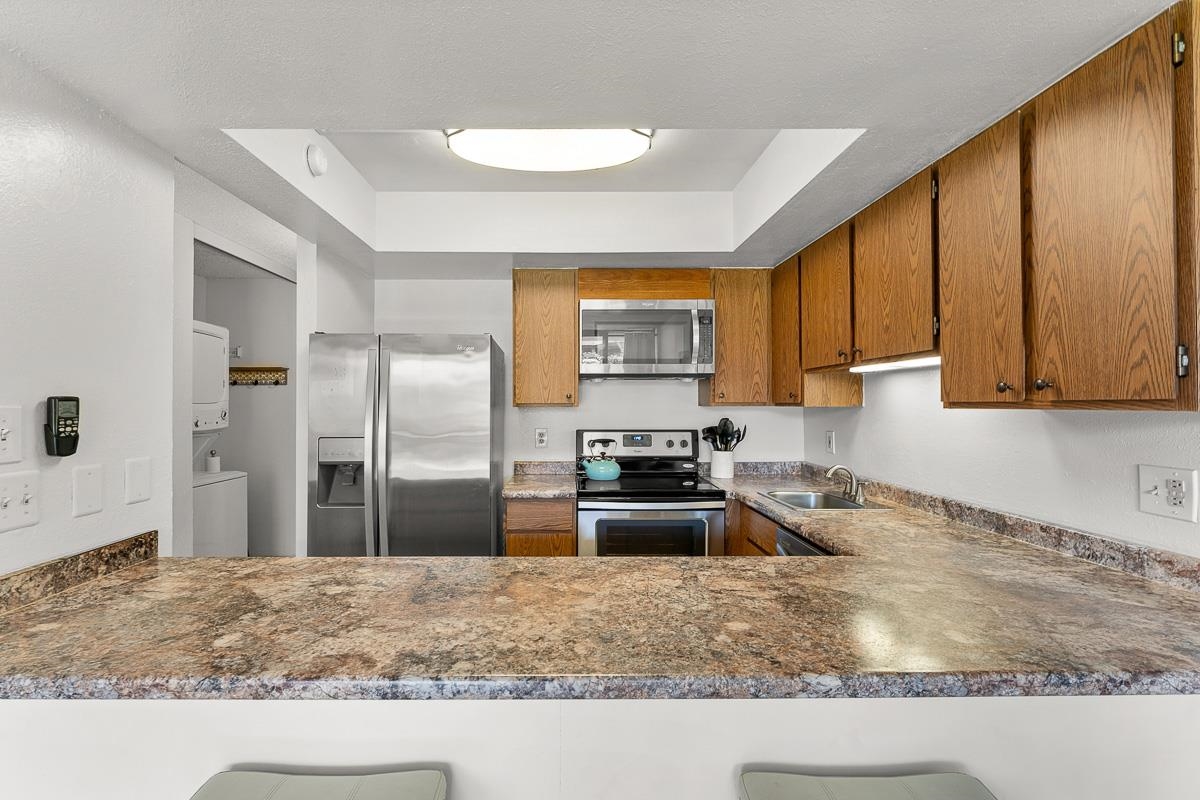 940 South Kihei Road, Unit B204 Kihei, HI 96753 - Photo 11 of 30 a kitchen with stainless steel appliances granite countertop a refrigerator stove and sink