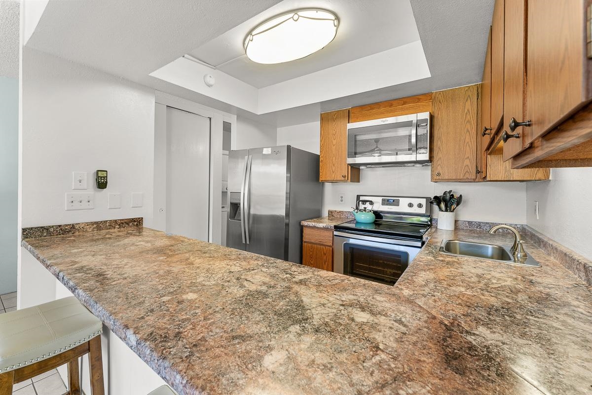 940 South Kihei Road, Unit B204 Kihei, HI 96753 - Photo 12 of 30 a kitchen with stainless steel appliances granite countertop a sink stove and refrigerator