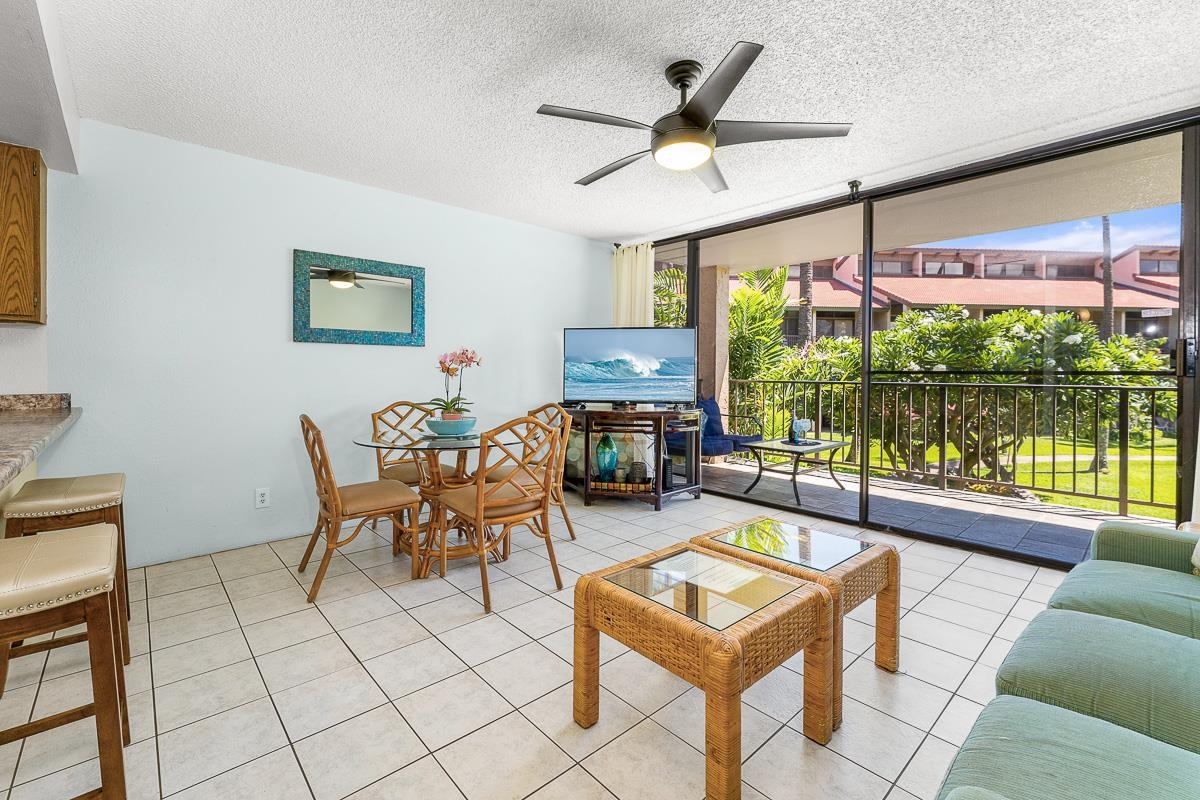 940 South Kihei Road, Unit B204 Kihei, HI 96753 - Photo 3 of 30 a living room with furniture a flat screen tv and a floor to ceiling window
