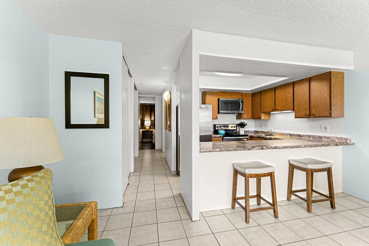 940 South Kihei Road, Unit B204 Kihei, HI 96753 - Photo 4 of 30 a kitchen with granite countertop white cabinets and appliances