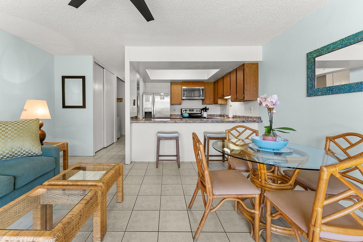 940 South Kihei Road, Unit B204 Kihei, HI 96753 - Photo 8 of 30 a kitchen with stainless steel appliances kitchen island granite countertop a table and chairs in it