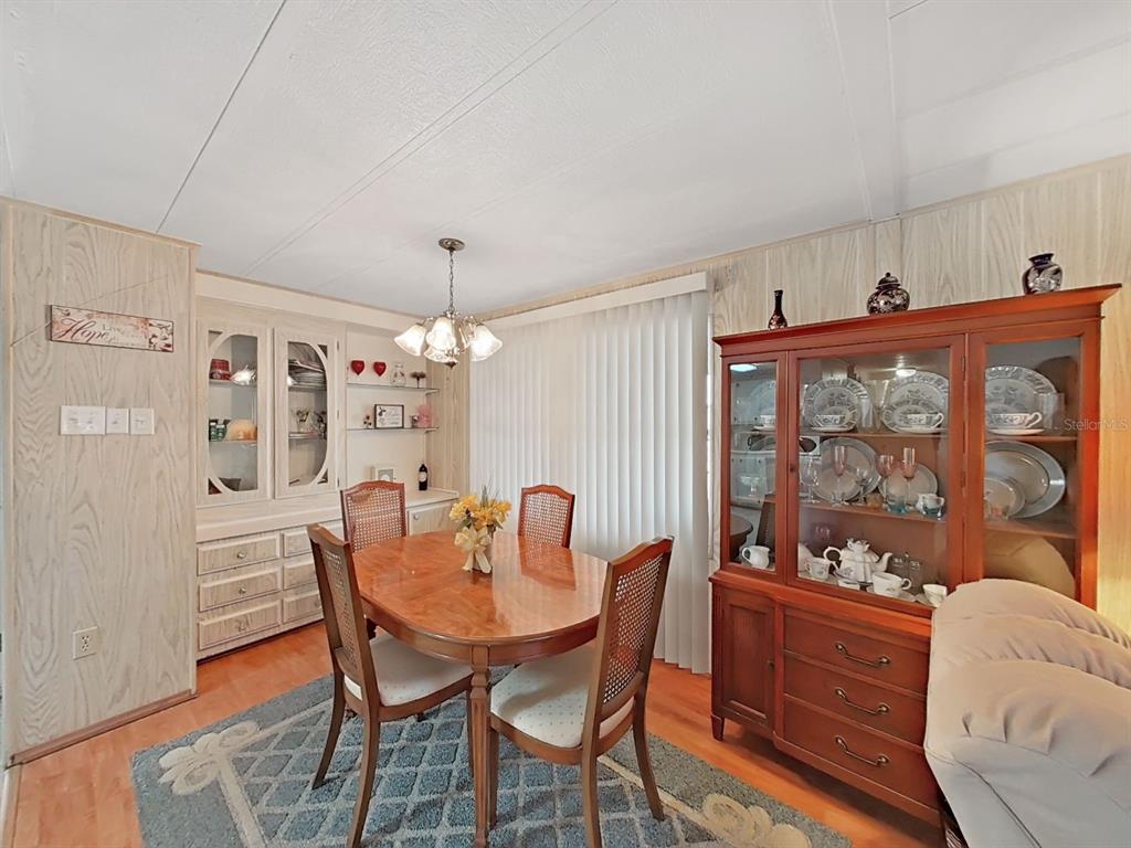 12501 Ulmerton Road, Unit 140 Largo, FL 33774 - Photo 7 of 20 a dining room with furniture a chandelier and window