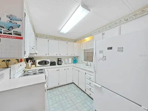 a kitchen with white cabinets and white appliances