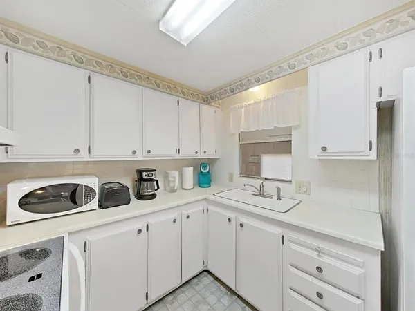 a kitchen with white cabinets and white appliances