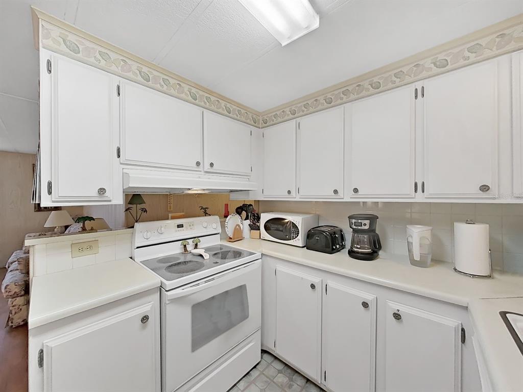 12501 Ulmerton Road, Unit 140 Largo, FL 33774 - Photo 10 of 20 a kitchen with a sink a stove and cabinets