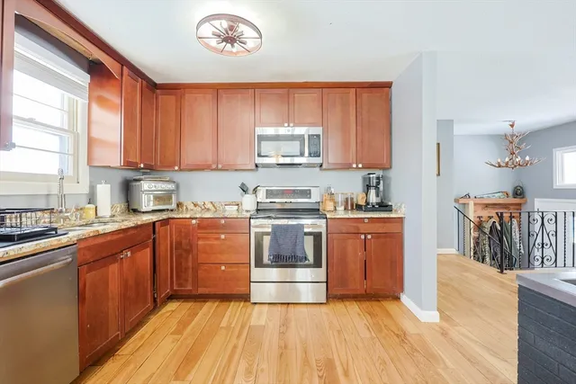 a kitchen with stainless steel appliances granite countertop a stove a sink dishwasher and a refrigerator