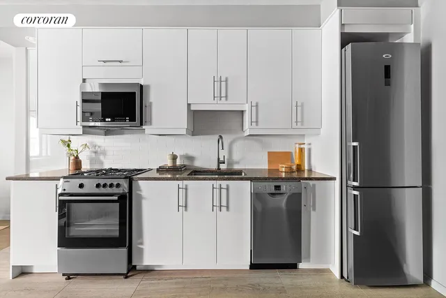 a kitchen with stainless steel appliances granite countertop a stove and a refrigerator