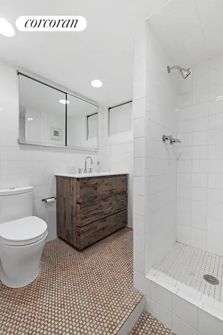 a bathroom with a sink a toilet and shower