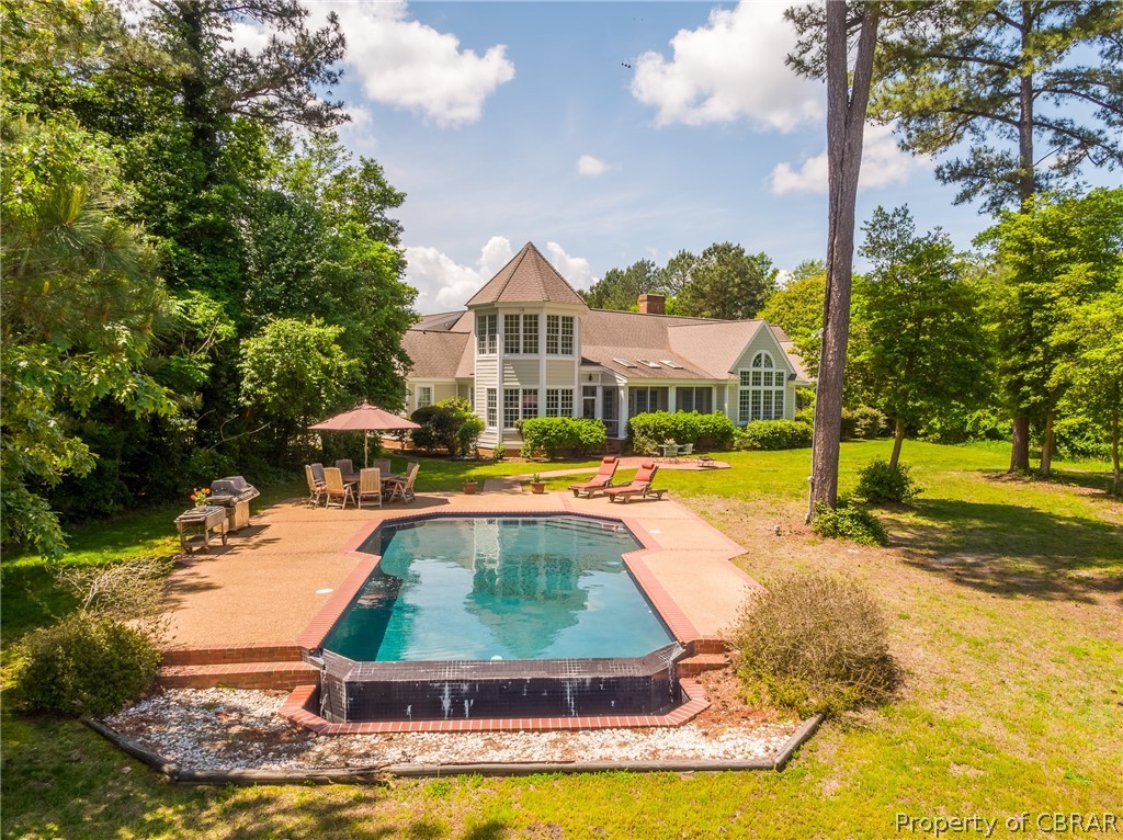1193 West Point Road Lancaster, VA 22503 - Photo 2 of 50 a view of a swimming pool with lawn chairs and plants