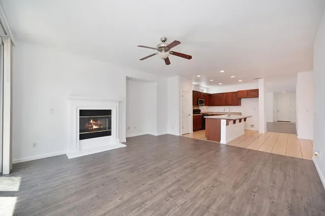 a view of an empty room with a window and wooden floor