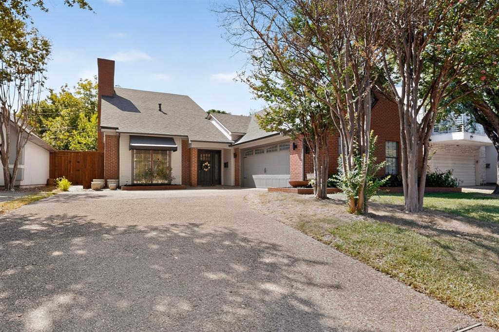 1526 Abrams Road Dallas, TX 75214 - Photo 1 of 38 Brick and white stucco exterior, prominent bay window with awning, attached two-car garage, and established trees