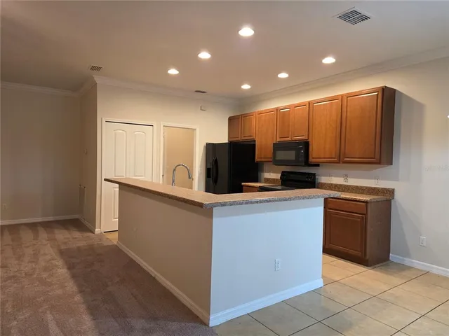a kitchen with stainless steel appliances granite countertop a refrigerator and a stove top oven