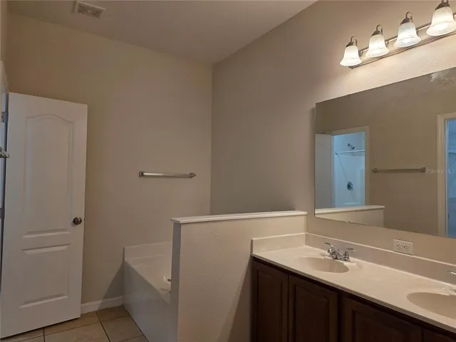 a bathroom with a sink a light fixture and a mirror