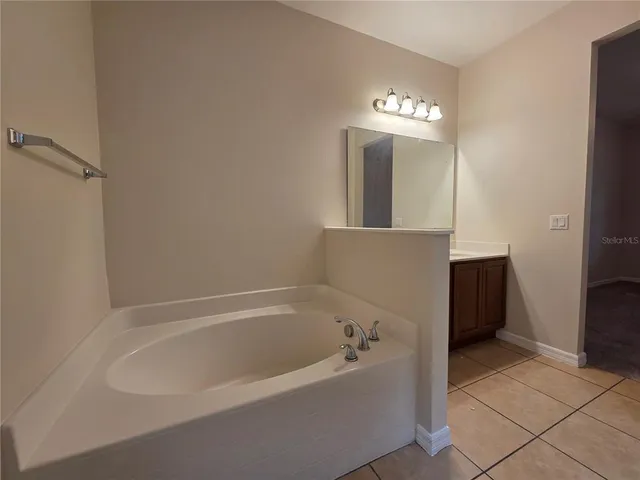a spacious bathroom with a bathtub and a chandelier