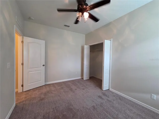 an empty room with closet and windows