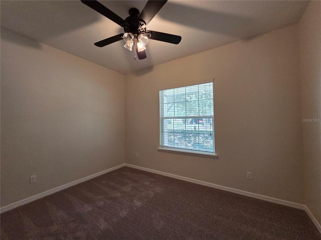 1571 Danisco Place Apopka, FL 32703 - Photo 21 of 26 an empty room with a chandelier fan and windows
