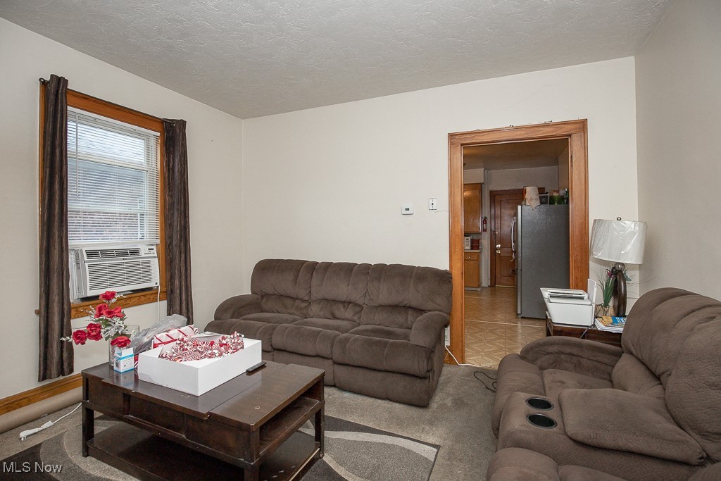 860 Whitcomb Road Cleveland, OH 44110 - Photo 5 of 12 Carpeted living room with cooling unit and a textured ceiling
