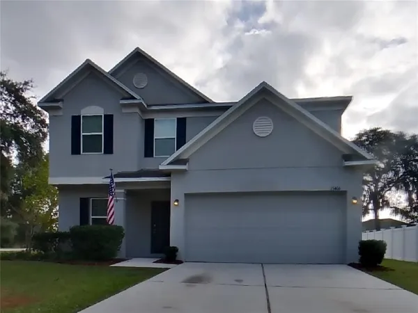 a front view of a house with a yard and a garage