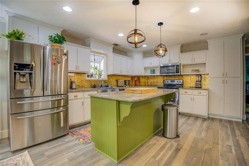 2100 Morgan Lane Covington, GA 30014 - Photo 23 of 47 a kitchen with kitchen island white cabinets and stainless steel appliances
