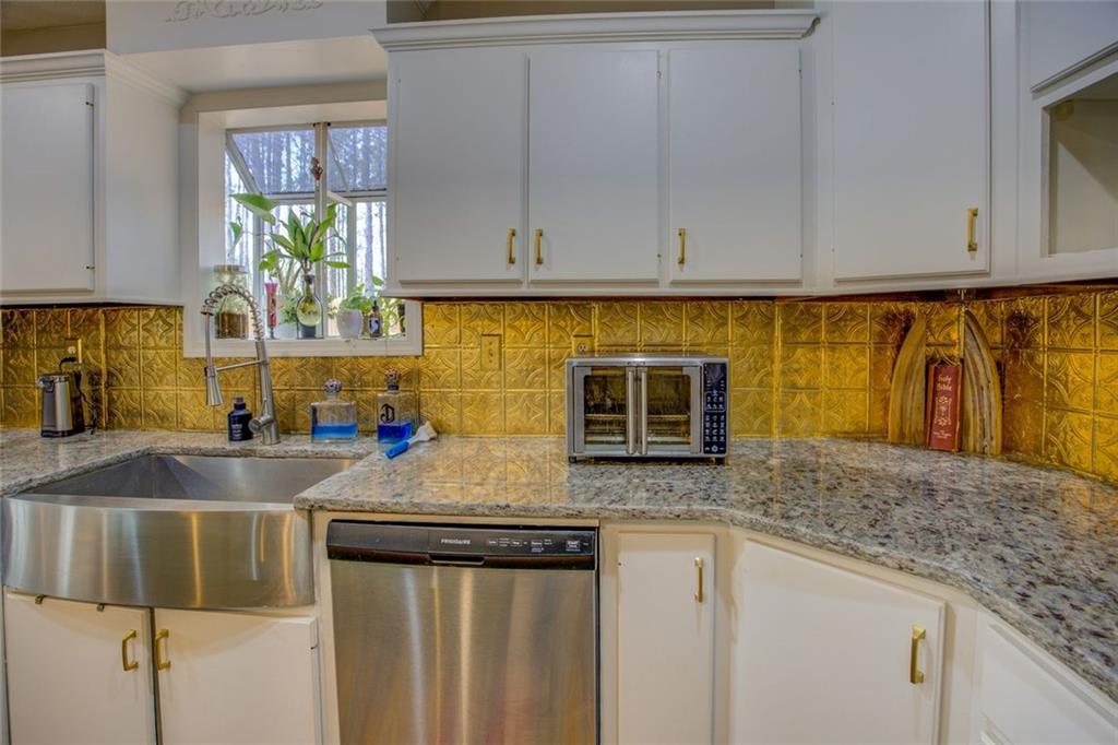 2100 Morgan Lane Covington, GA 30014 - Photo 25 of 47 a kitchen with stainless steel appliances granite countertop a sink stove and microwave