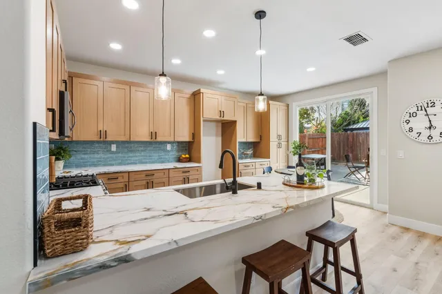 a kitchen with stainless steel appliances granite countertop a sink and a refrigerator