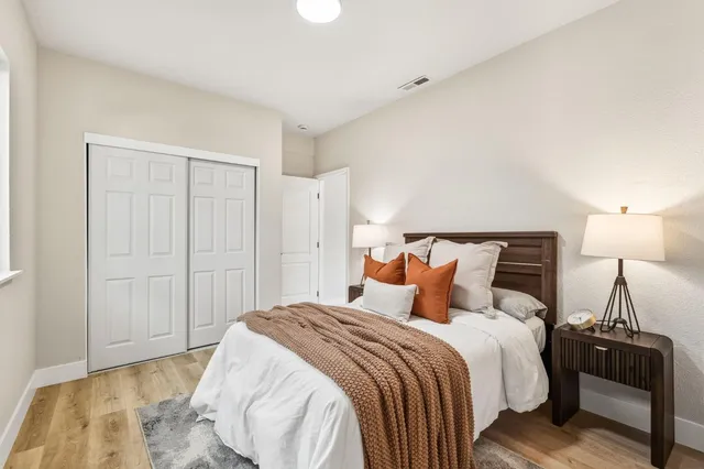 a bedroom with a bed and wooden floor