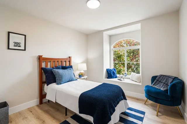 a bedroom with a bed window and couch