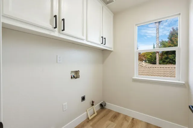 a bathroom with a window and a white cabinet