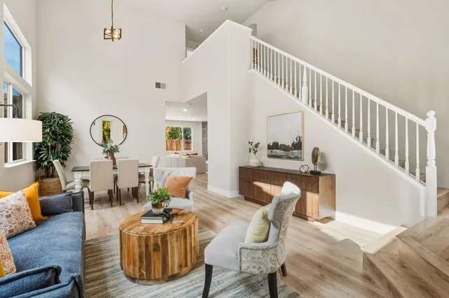 a living room with furniture chandelier and wooden floor