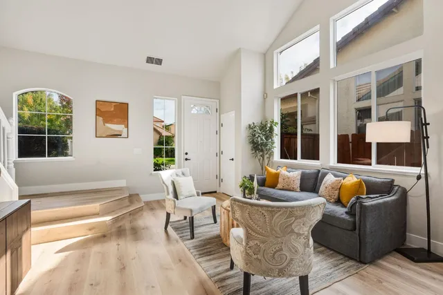 a living room with furniture and floor to ceiling windows