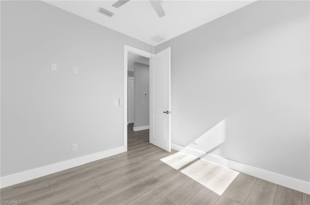 1323 Wesley Drive Punta Gorda, FL 33950 - Photo 18 of 50 an empty room with wooden floor and white walls