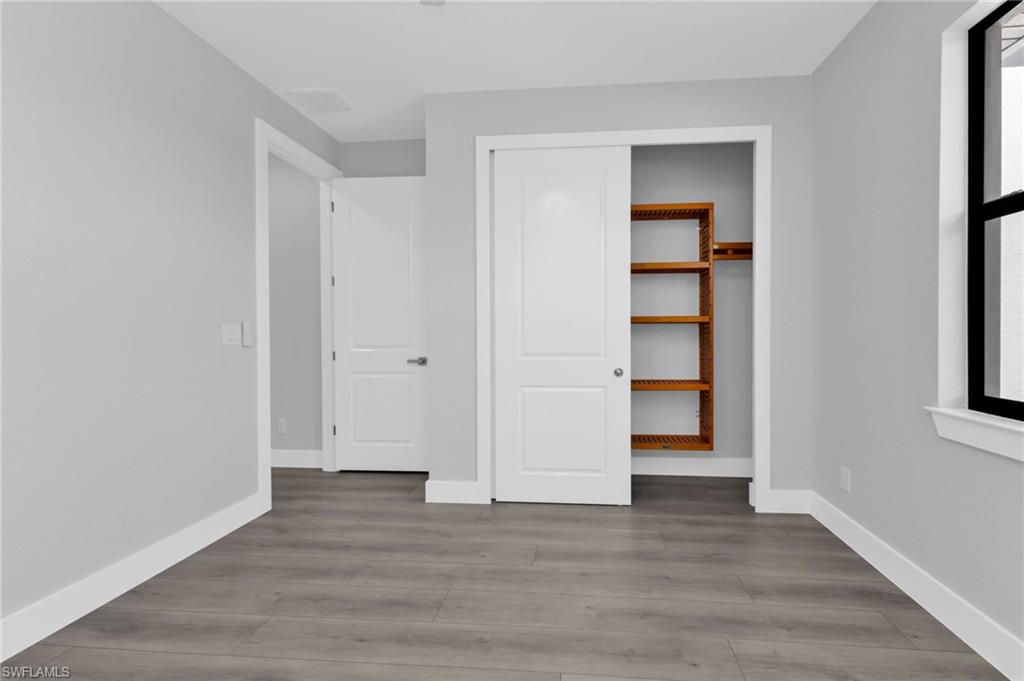 1323 Wesley Drive Punta Gorda, FL 33950 - Photo 26 of 50 a view of an empty room with closet and wooden floor