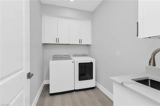 a utility room with sink dryer and washer