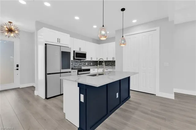 a kitchen with kitchen island a sink stainless steel appliances and cabinets