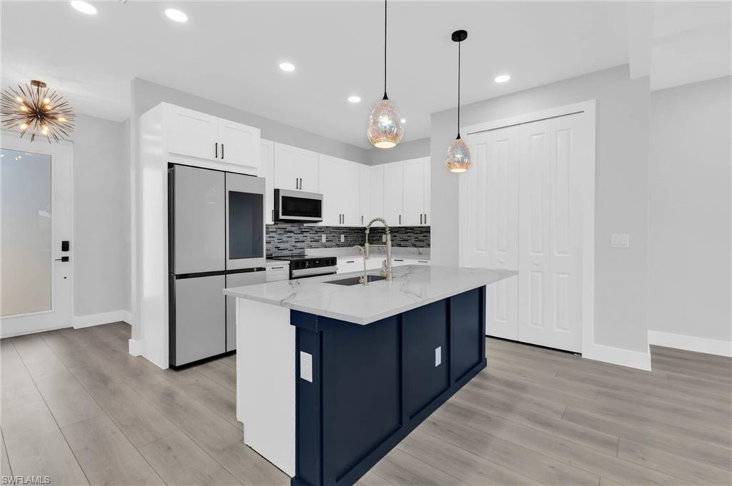 1323 Wesley Drive Punta Gorda, FL 33950 - Photo 6 of 50 a kitchen with kitchen island a sink stainless steel appliances and cabinets