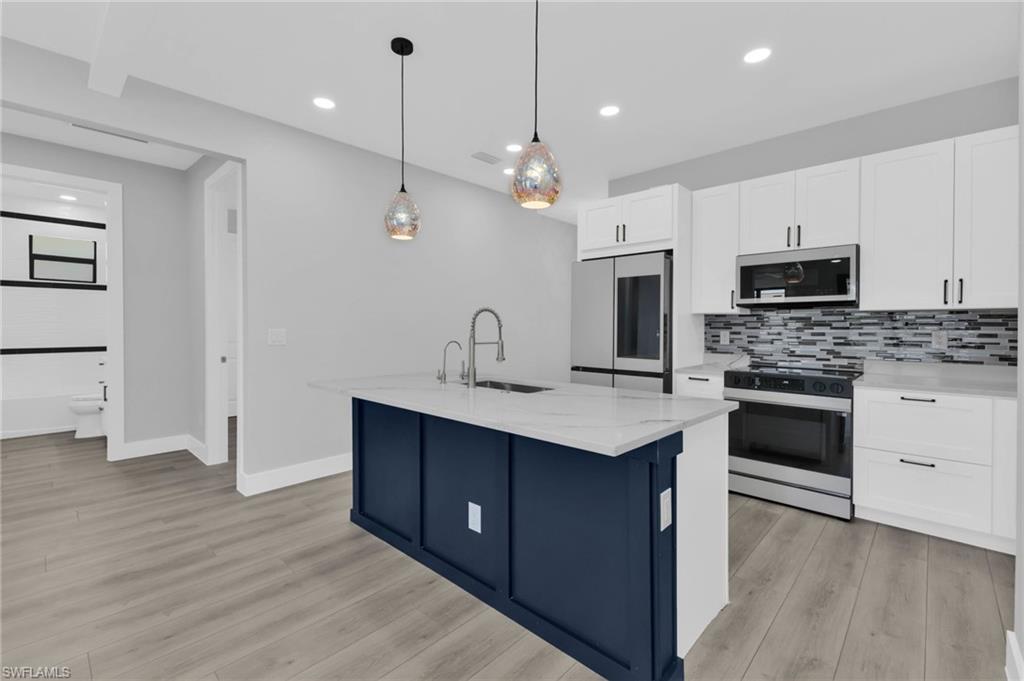 1323 Wesley Drive Punta Gorda, FL 33950 - Photo 9 of 50 a kitchen with kitchen island a sink stainless steel appliances and cabinets