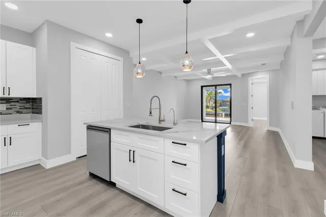 a kitchen with stainless steel appliances granite countertop a sink a stove a refrigerator and island with wooden floor