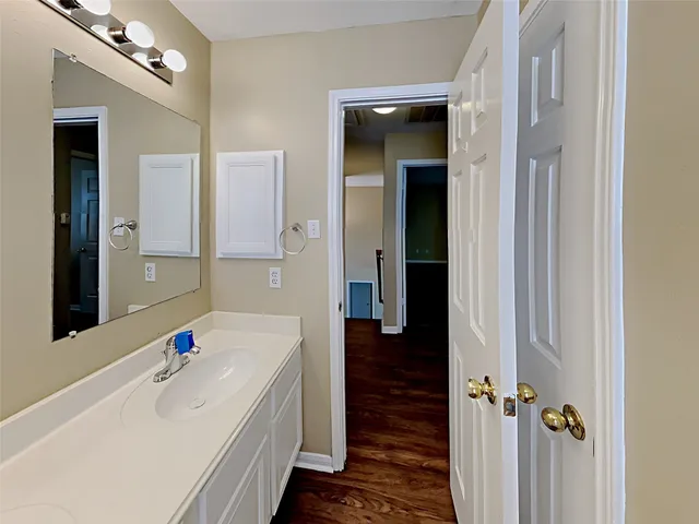 a bathroom with a tub a sink and a large mirror