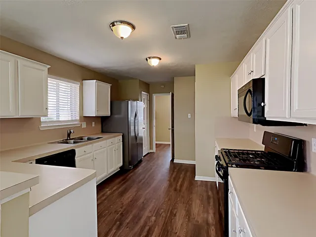 a kitchen with stainless steel appliances a refrigerator a stove a microwave a sink and cabinets