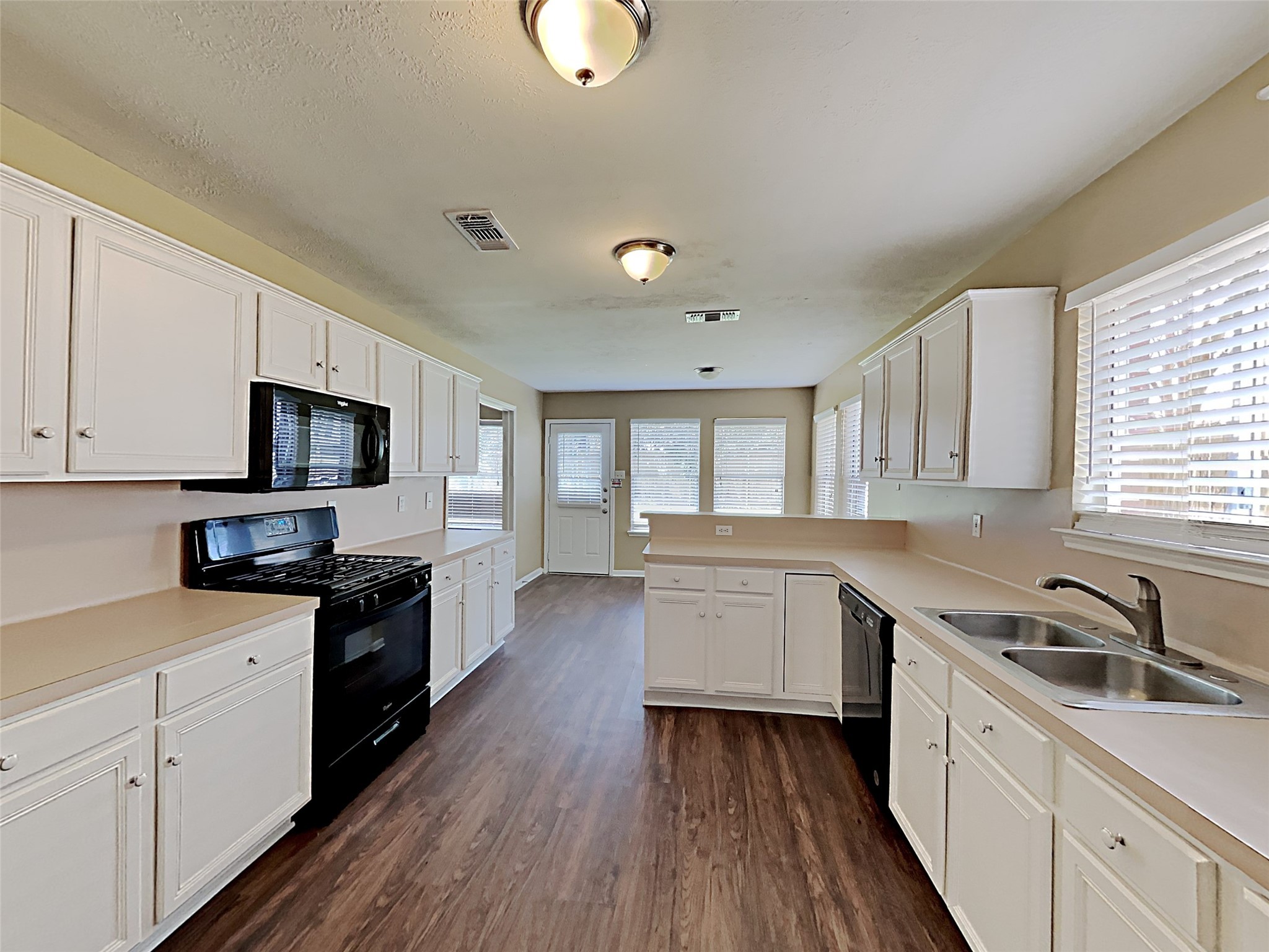 7203 Glen Rosa Drive Katy, TX 77494 - Photo 3 of 22 a kitchen with a sink wooden floor and stainless steel appliances