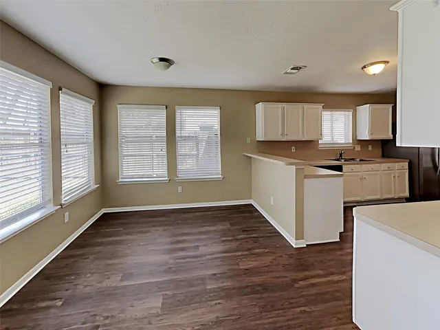 a kitchen with granite countertop a stove top oven sink and cabinets