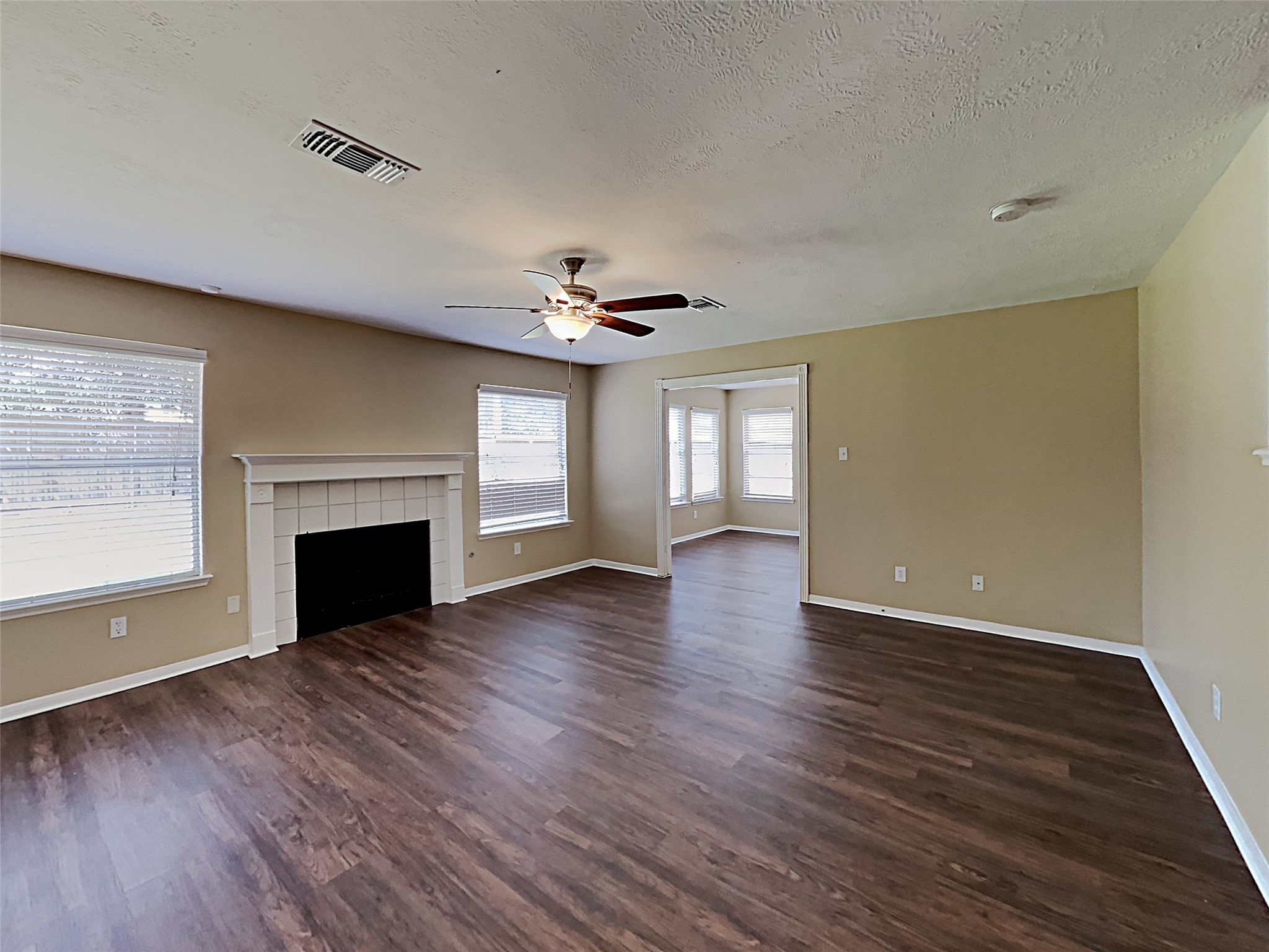 7203 Glen Rosa Drive Katy, TX 77494 - Photo 6 of 22 an empty room with wooden floor fireplace and windows