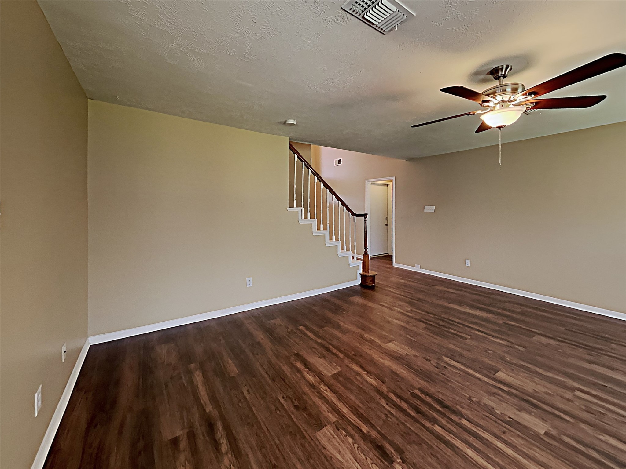 7203 Glen Rosa Drive Katy, TX 77494 - Photo 7 of 22 a view of an empty room with wooden floor and a ceiling fan