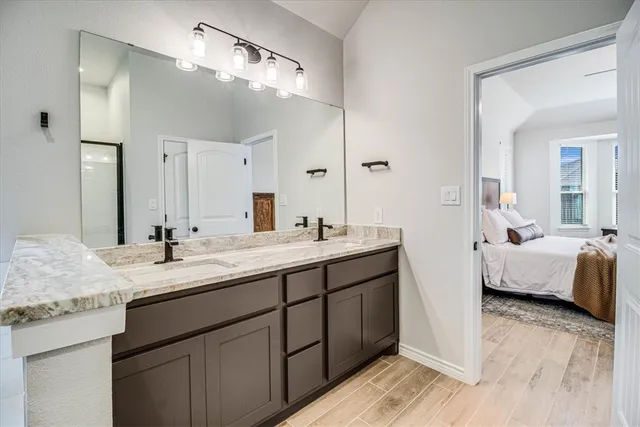 a en suite bathroom with a double vanity sink and a mirror