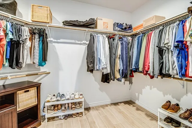 a view of walk in closet with clothes and shoes