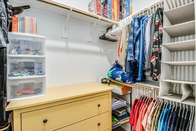 a view of walk in closet with clothes and shoes