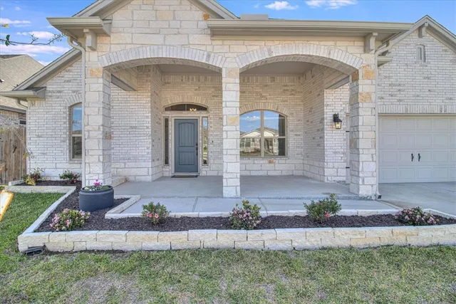 a front view of a house with a garden and plants