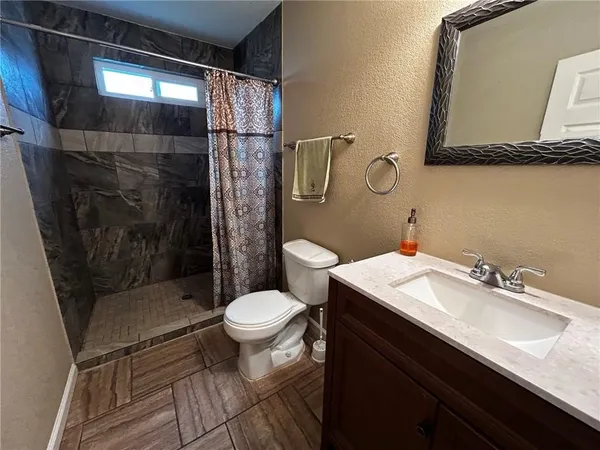 a bathroom with a sink toilet and shower